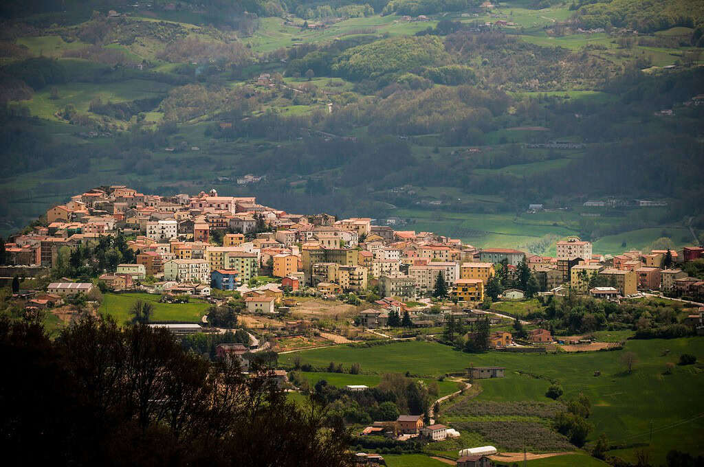 Un villaggio circondato da colline verdi.