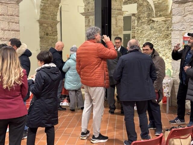 Foto di un evento con degustazione di vini e discussioni tra appassionati e produttori.