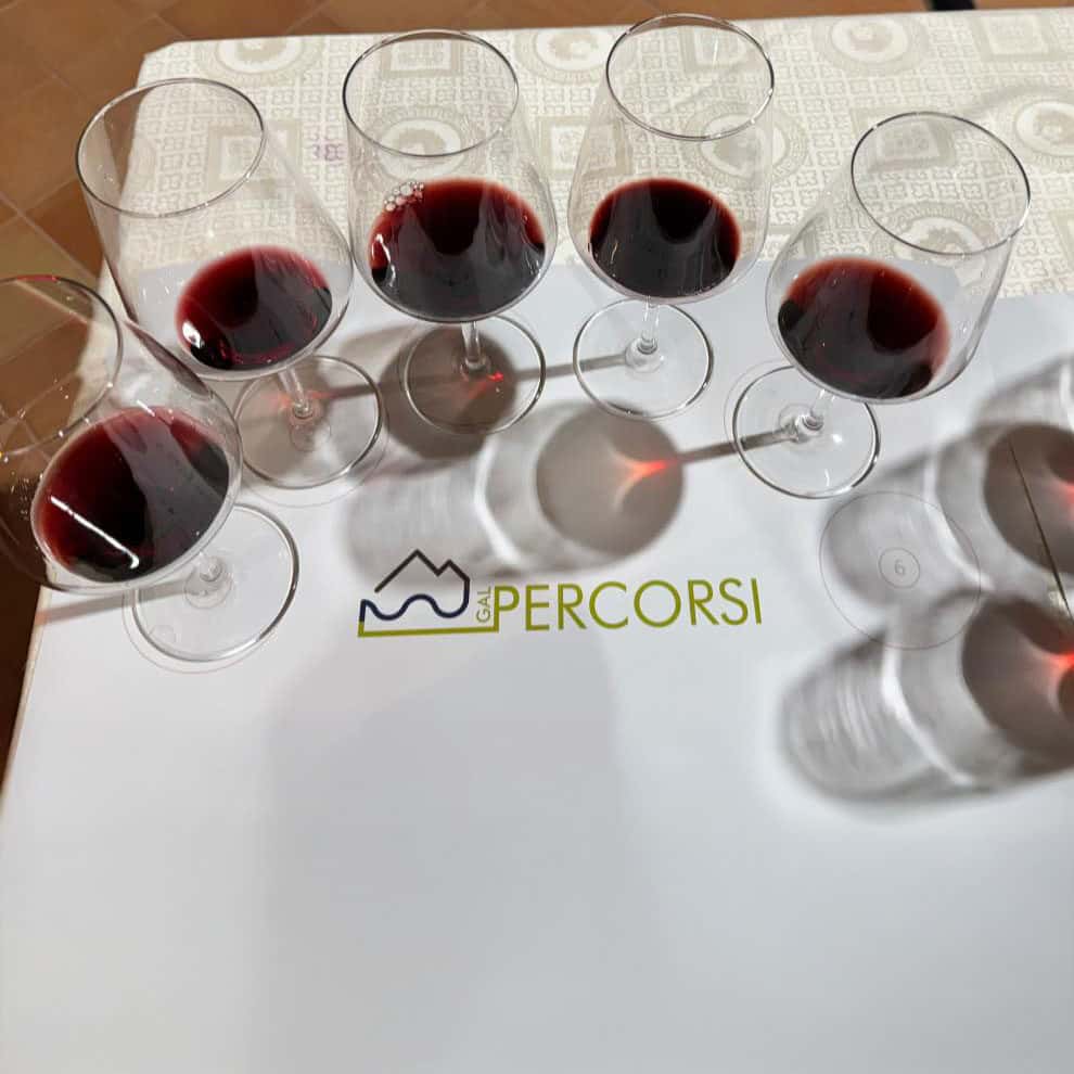 Cinque bicchieri di vino rosso.