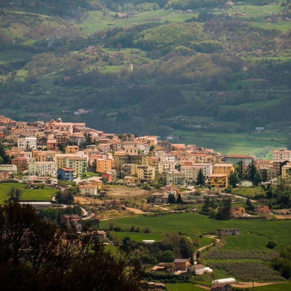 Un villaggio circondato da colline verdi.